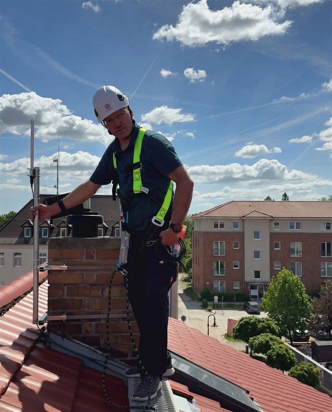 HKE-Monteur montiert die Funk-Antenne auf einem Dach in der Lausitz.