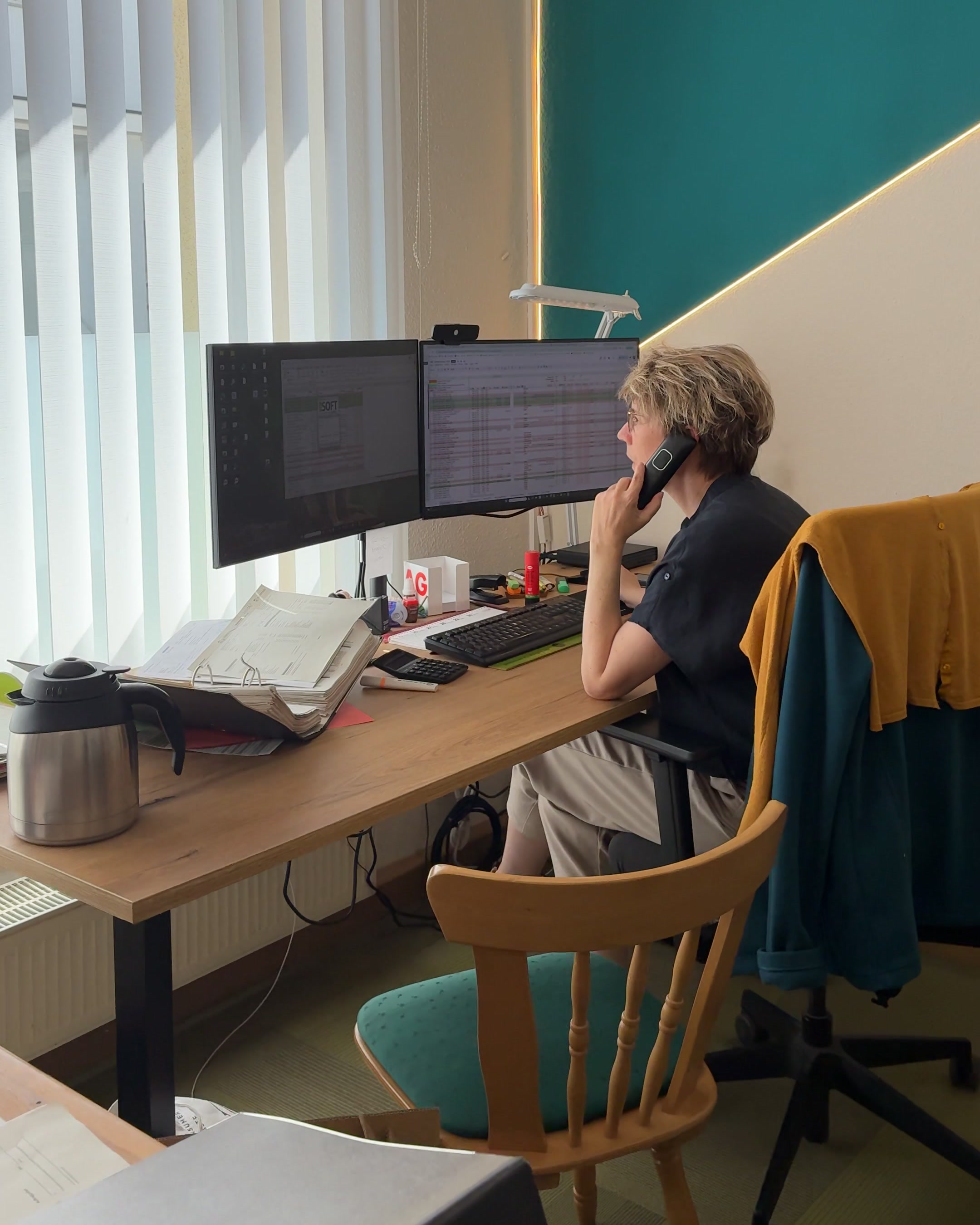 HKE-Mitarbeiterin prüft Abrechnungsdaten am Doppelmonitor im Innendienst.