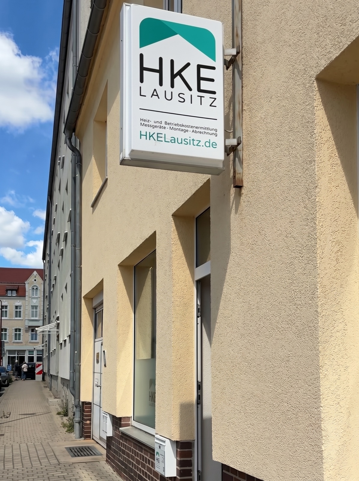 Außen­ansicht des HKE-Büros in Weiß­wasser/O.L. mit der HKE-Lausitz-Leucht­werbung an der Fassade.