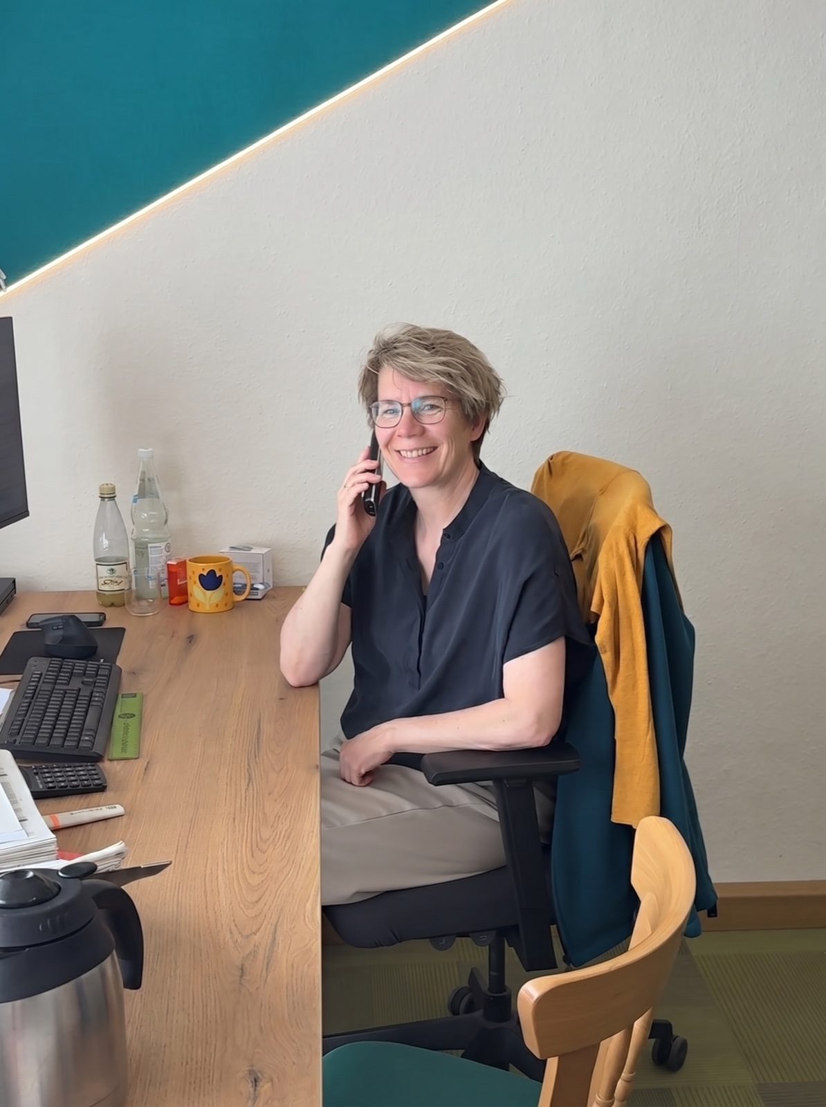 HKE-Mitarbeiterin im Innendienst telefoniert lächelnd am Schreibtisch im Lausitzer Büro.